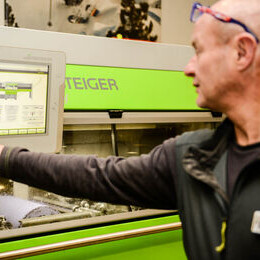 Bediener stellt eine STEIGER serviceproduktionsmaschine über ihr Touchscreen-Bedienfeld ein.