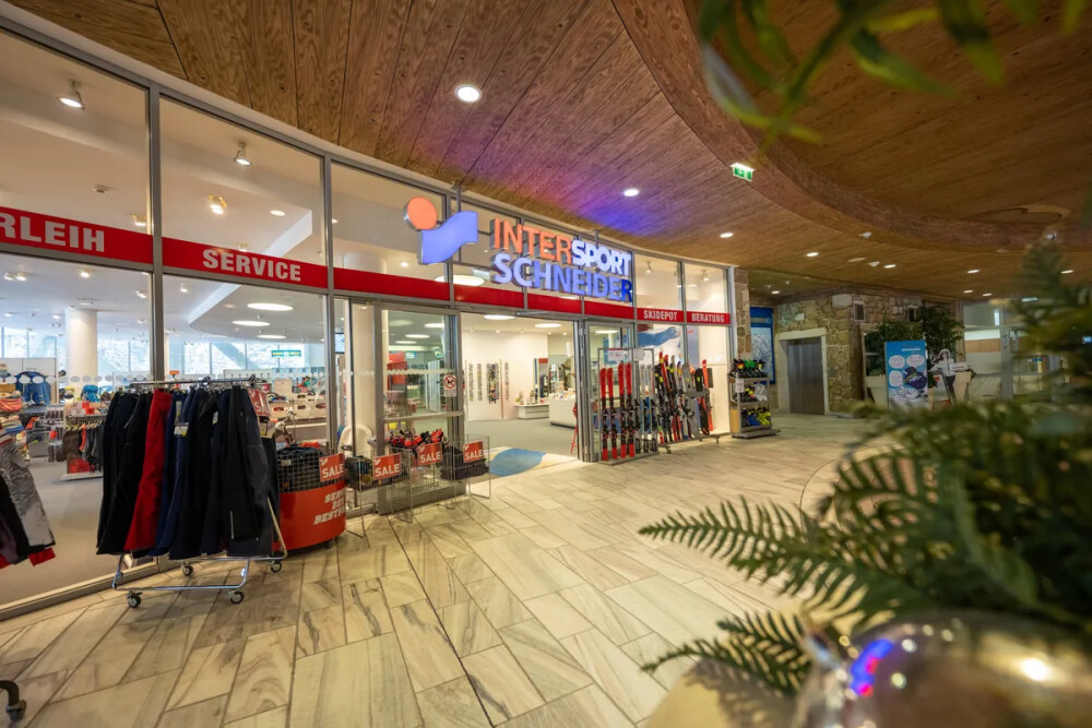 Moderner Intersport Scherer Ladeneingang, mit Skiverleih, Service und Wintersportausrüstung.