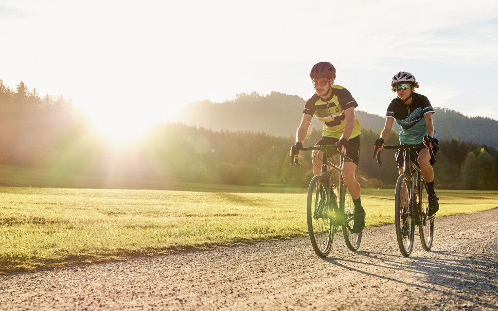 Mann und Frau mountainbiken auf einem üppigen Waldweg und genießen ein aktives Outdoor-Abenteuer.